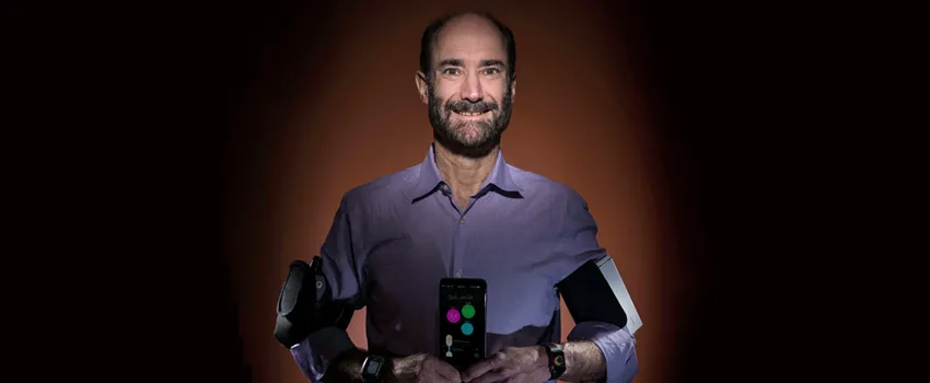 Photo of Dr. Michael Snyder using several wearable devices at once.