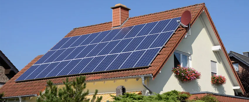 Photo of a house with numerous solar panels on the roof.