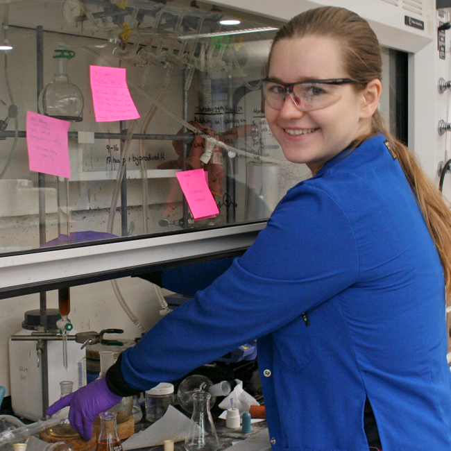 Photo of graduate student Anna Elleman in the lab, working in a tissue culture hood.