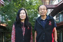 Photo of Drs. Ada Poon and H.-S. Phillip Wong standing in front of the Clark Center wearing fleece vests with the Bio-X logo. 